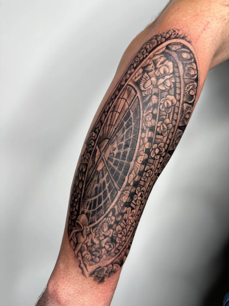 Rosone barocco tatuato sull'avambraccio in black & grey